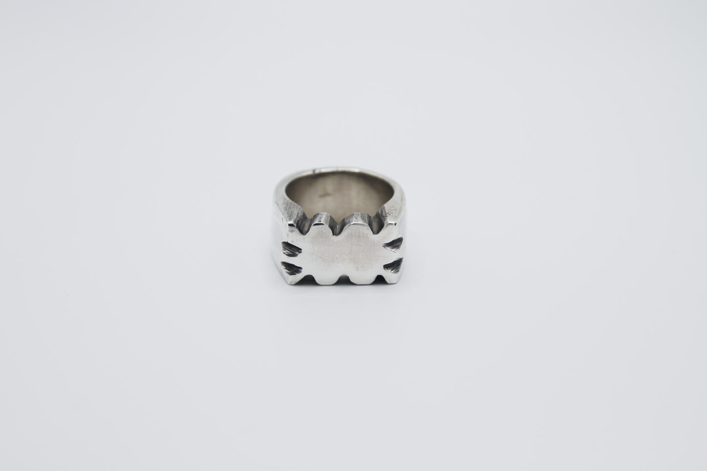 The Nibble Ring. 925 Solid Sterling Silver Chunky Ring band hand made in the United Kingdom. This ring has a wavy and unique design, displaying a wiggly edged design in the centre of the ring face. For all genders and ring sizes.