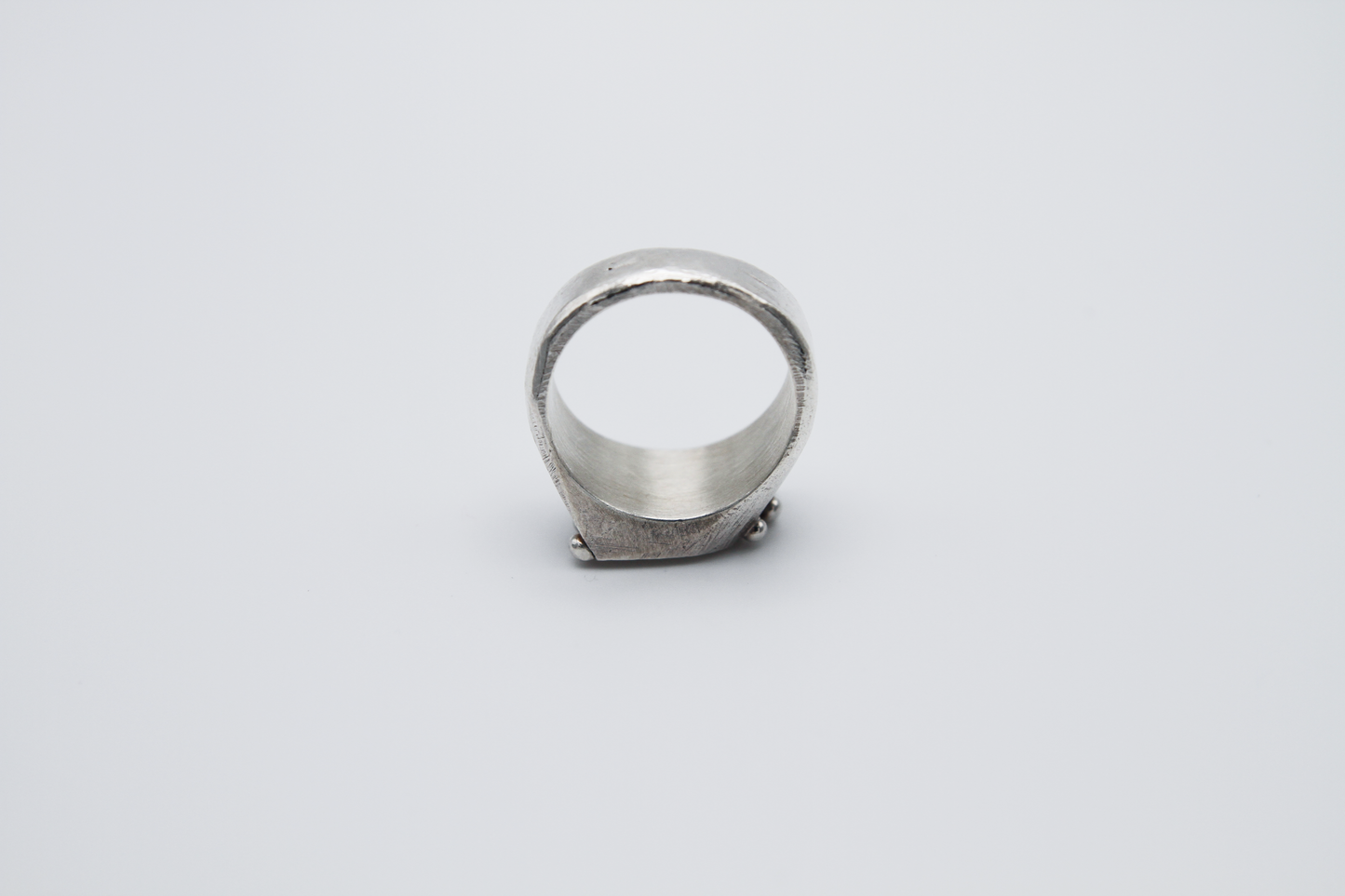 The Dew Drop Signet. 925 Solid Sterling Silver Ring hand made in the United Kingdom. This ring fashions a signet styler shape that slants to the left in a pointed oval shape. There are 3 silver balls on each side of the ring face.