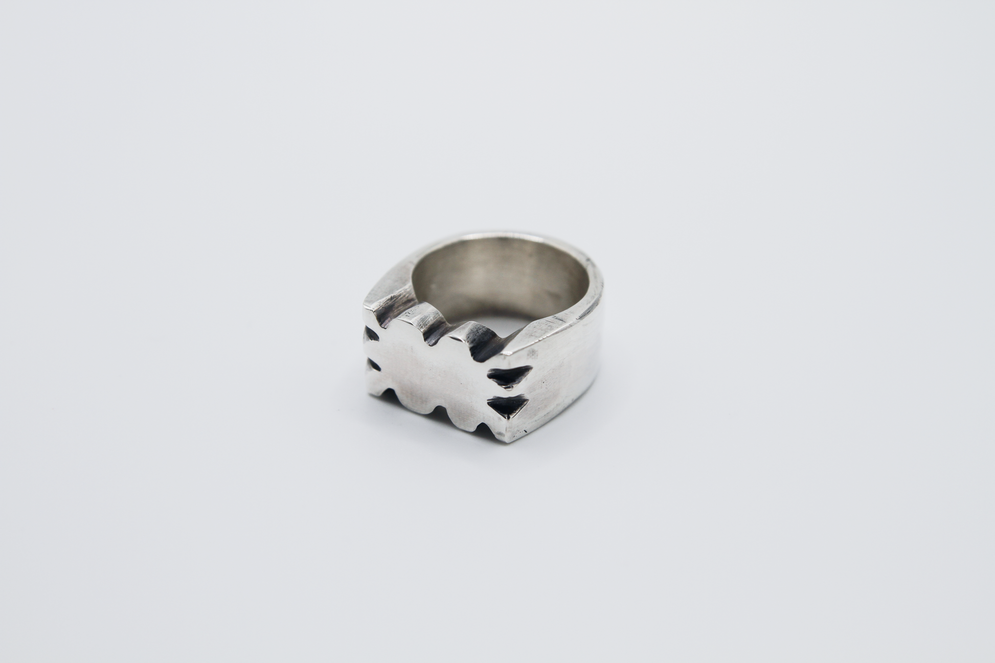The Nibble Ring. 925 Solid Sterling Silver Chunky Ring band hand made in the United Kingdom. This ring has a wavy and unique design, displaying a wiggly edged design in the centre of the ring face. For all genders and ring sizes.