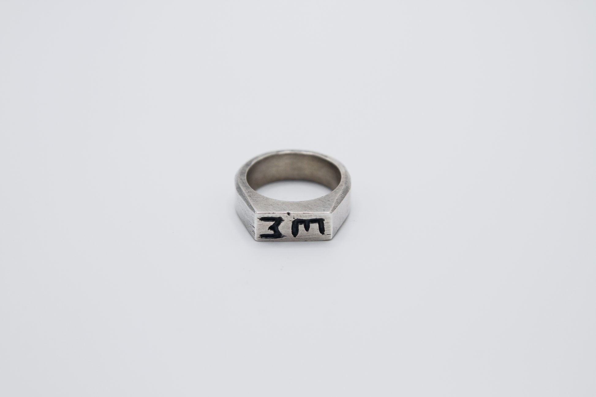 The Rough Cut Initials Ring. 925 Solid Sterling Silver Chunky Ring band hand made in the United Kingdom. This Signet ring is designed to sit on your pinky finger as they are classicaly worn. Put your initials in places of a coat of arms. For all genders and ring sizes.