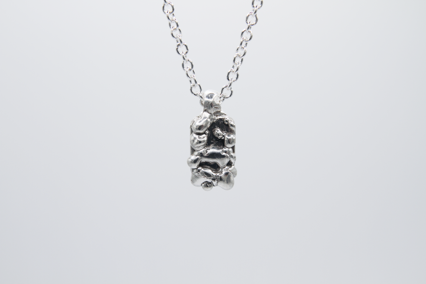 The Treacle Pendant Necklace. 925 Solid Sterling Silver Pendant Necklace hand made in the United Kingdom. This necklace displays a tag style pendant with a melted and dripping texture formed by solid sterling silver. This pendant sits on an 18 inch cable chain. For all genders.