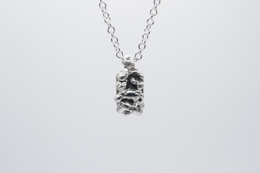 The Treacle Pendant Necklace. 925 Solid Sterling Silver Pendant Necklace hand made in the United Kingdom. This necklace displays a tag style pendant with a melted and dripping texture formed by solid sterling silver. This pendant sits on an 18 inch cable chain. For all genders.