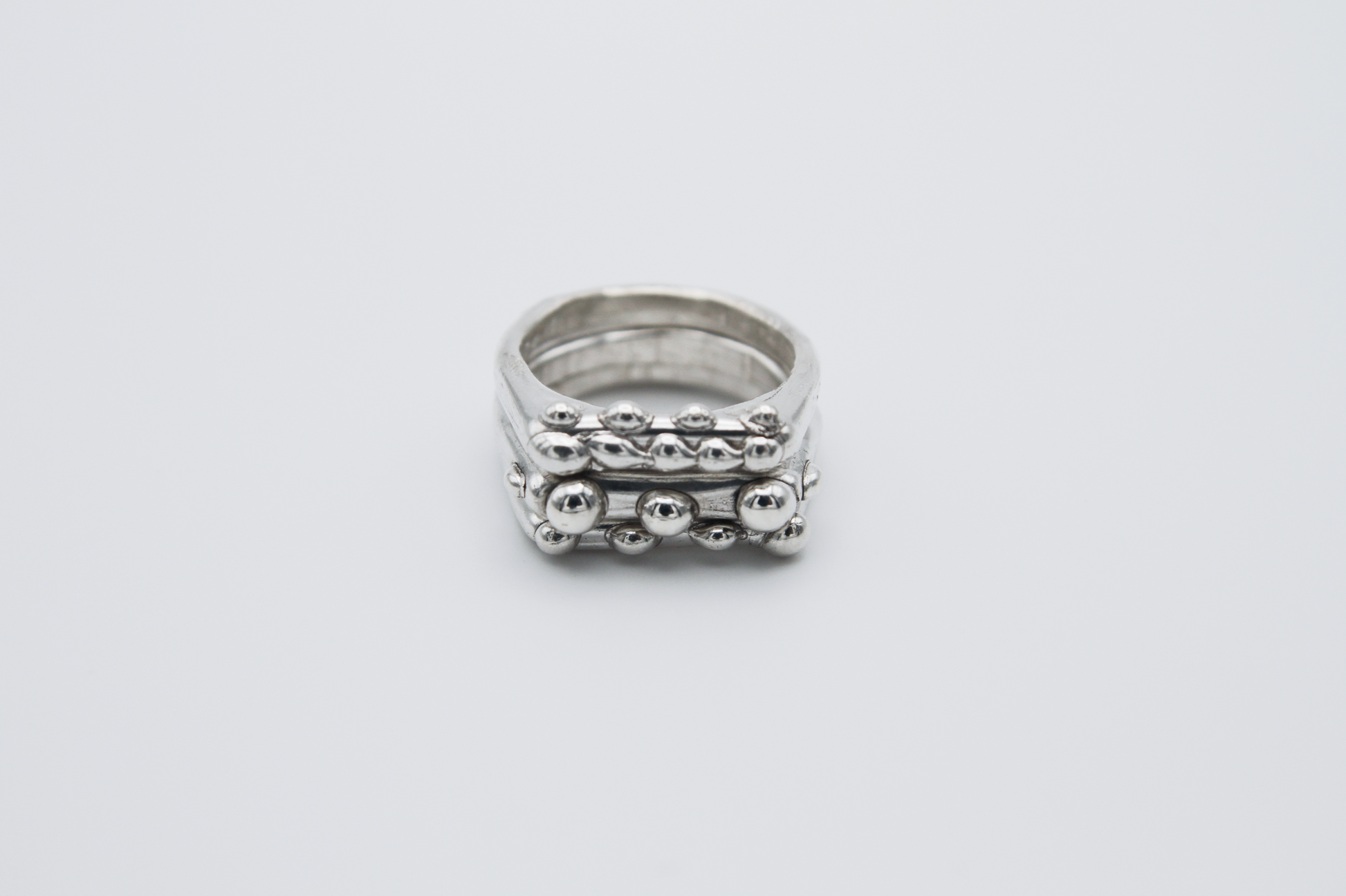 The Dew Drop Signet Ring Stack. 925 Solid Sterling Silver Chunky Ring band hand made in the United Kingdom. These stacking rings fashion blobs and drops of sterling silver in a bespoke and organic deisgn. Stack these three rings however you like, to be worn together or separately. For all genders and ring sizes.