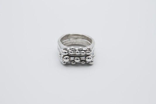 The Dew Drop Signet Ring Stack. 925 Solid Sterling Silver Chunky Ring band hand made in the United Kingdom. These stacking rings fashion blobs and drops of sterling silver in a bespoke and organic deisgn. Stack these three rings however you like, to be worn together or separately. For all genders and ring sizes.