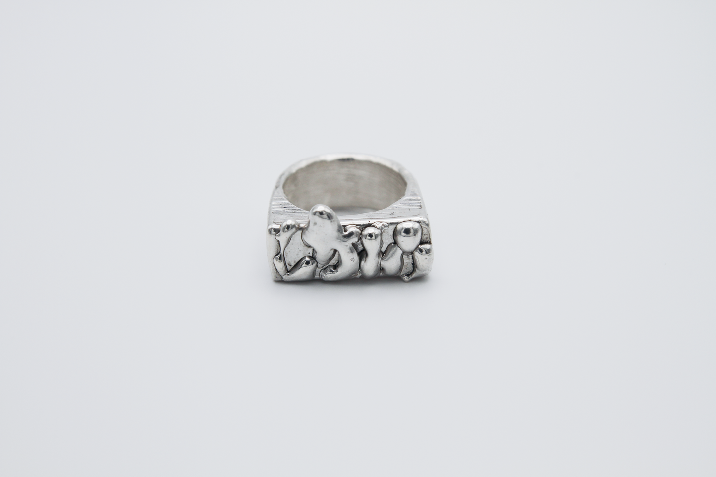The Treacle Signet Ring. 925 Solid Sterling Silver Chunky Ring hand made in the United Kingdom. This ring has a rectangular face with drips of sterling silver giving a melted and organic look. For all genders and ring sizes.